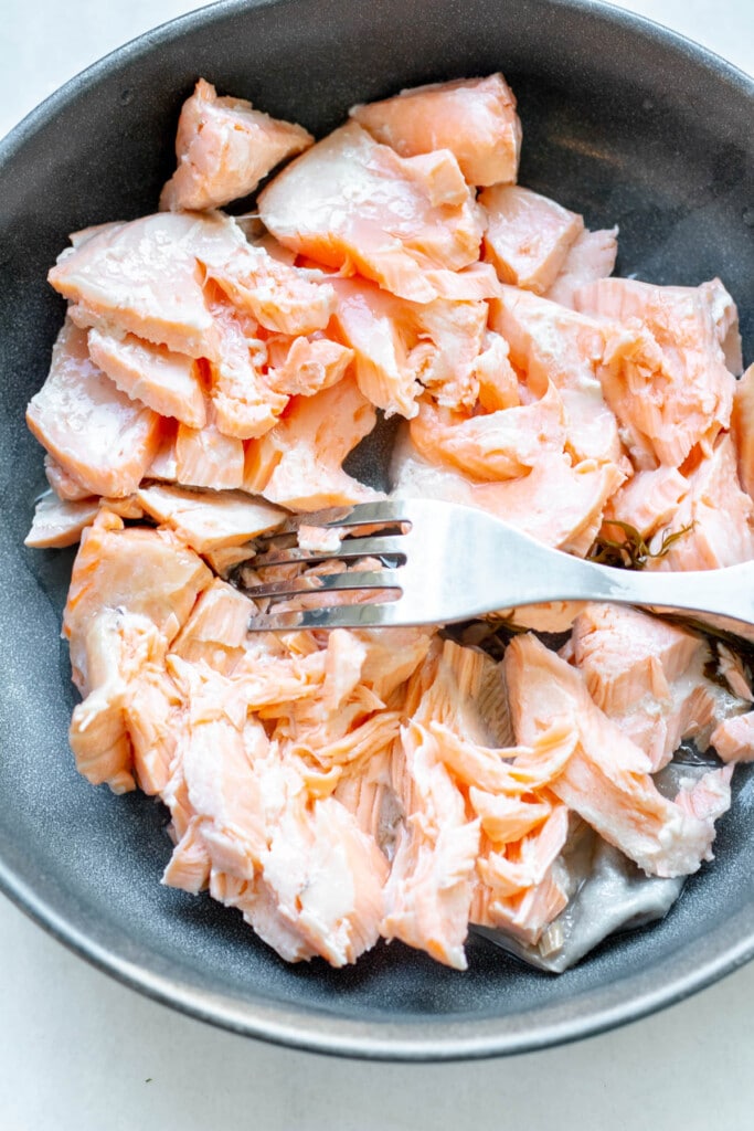 a plate of salmon, flaked with a fork