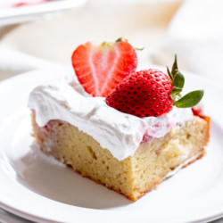 slice of Paleo Strawberry Poke Cake on white background