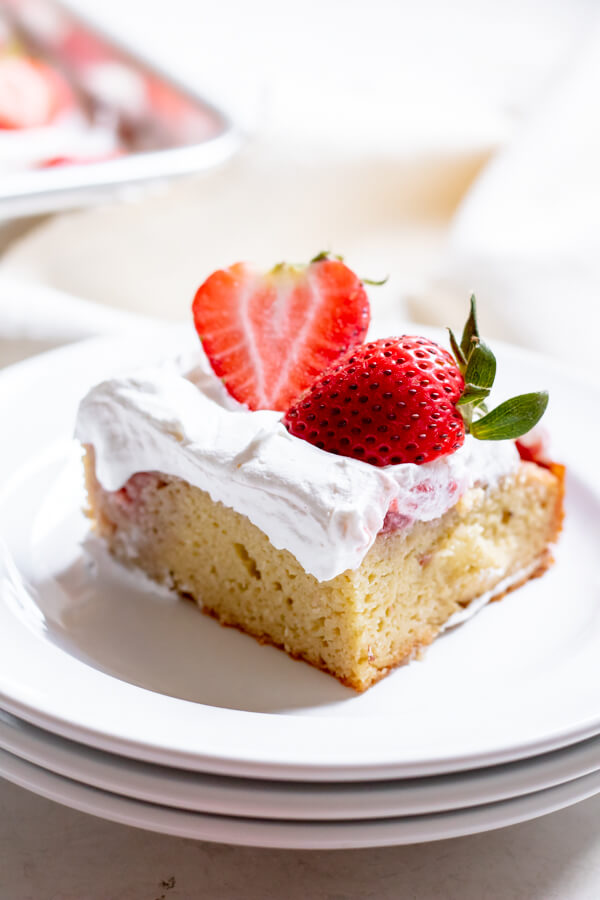 slice of Paleo Strawberry Poke Cake on white background