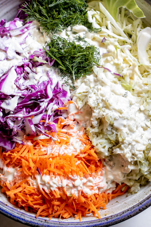 Cabbage in a bowl with dressing for Close up of Dill Pickle Coleslaw