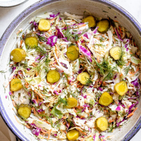 Large bowl of Close up of Dill Pickle Coleslaw in a purple bowl on white background