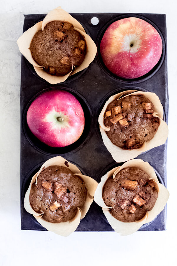 small muffin tray with apple spice muffins and apples