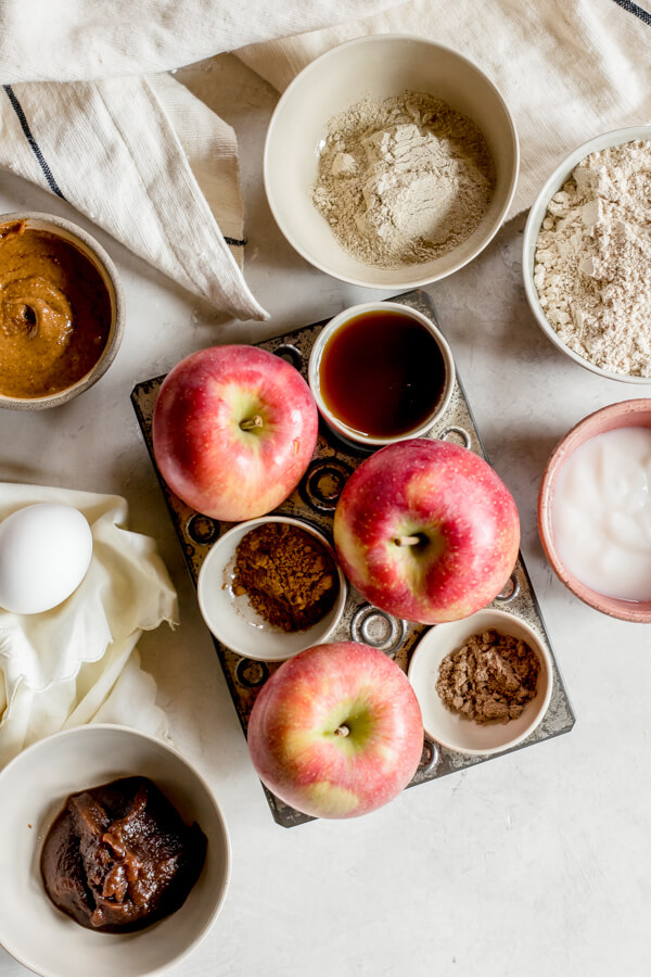 ingredients needed for apple spice muffins in small bowls on white background