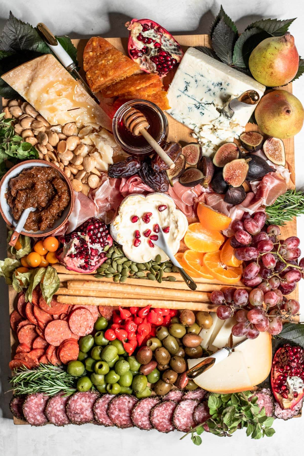OVER THE TOP BOARD FILLED WITH CHEESE, MEATS, NUTS, AND FRUIT