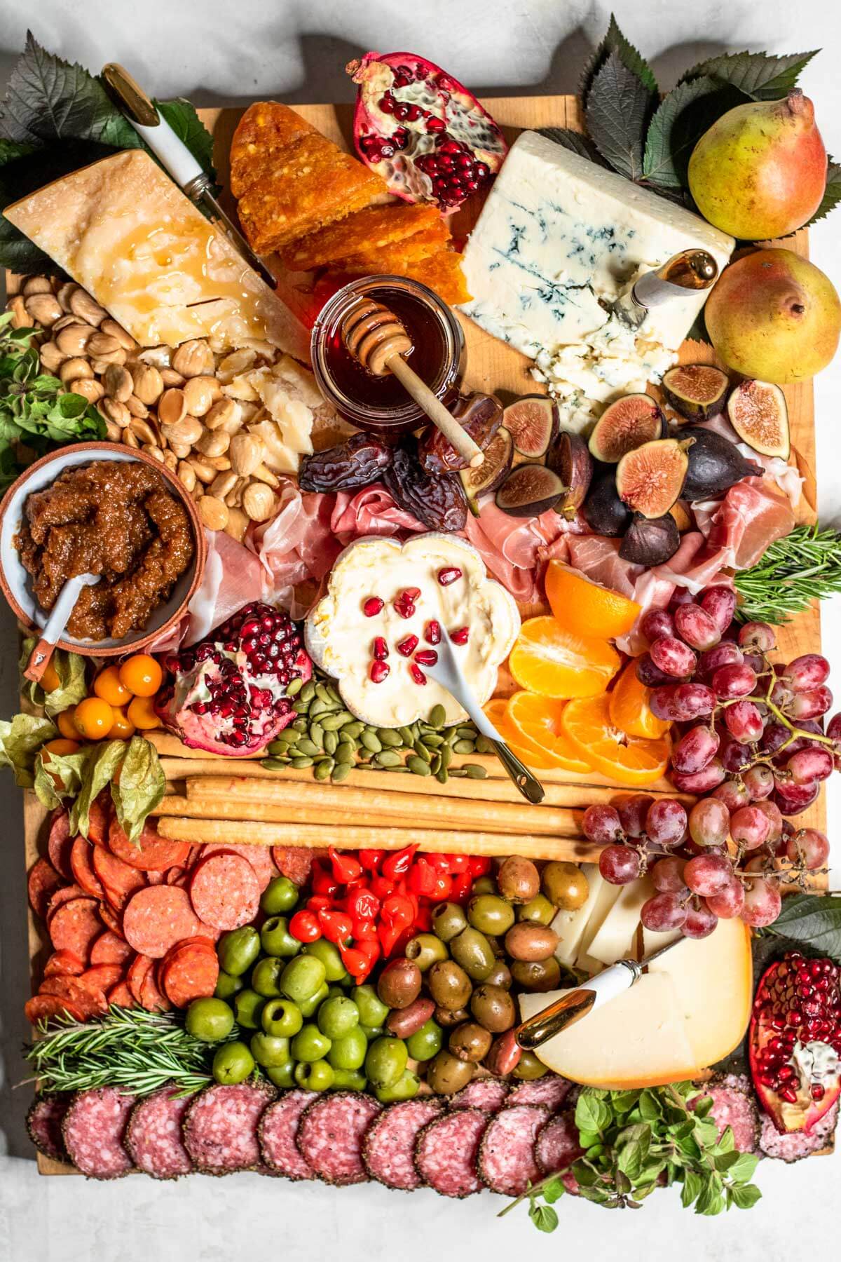 OVER THE TOP BOARD FILLED WITH CHEESE, MEATS, NUTS, AND FRUIT