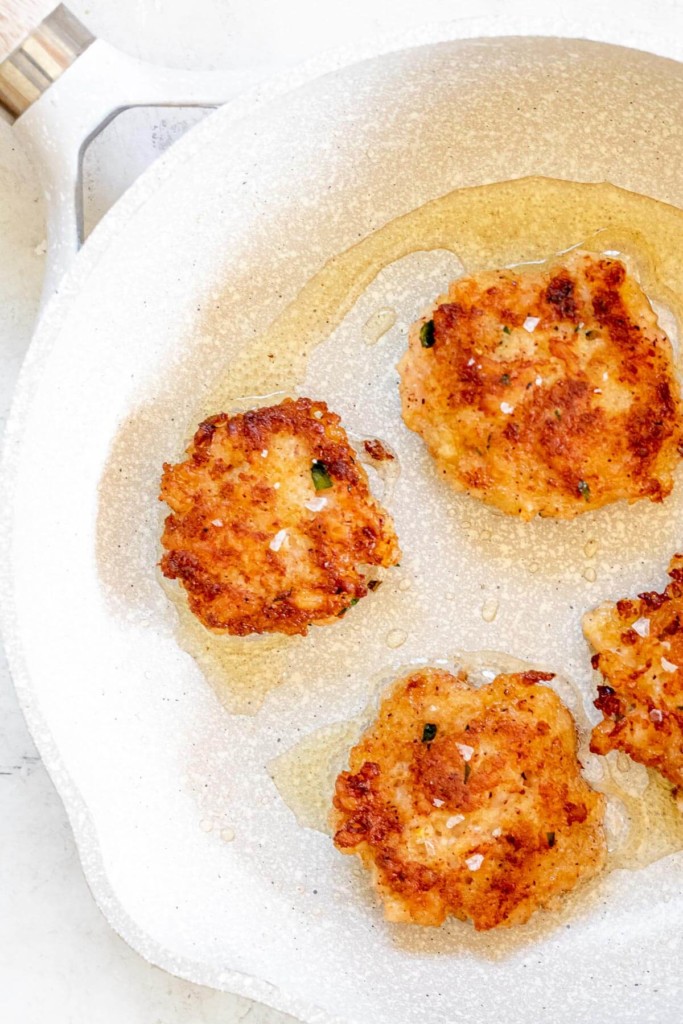 small white frying pan with crispy shrimp cakes