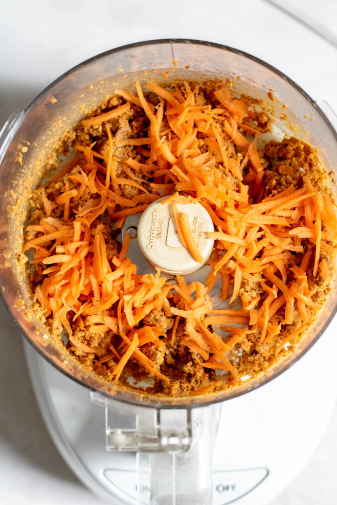 food processor with shredded carrots, dates and walnuts