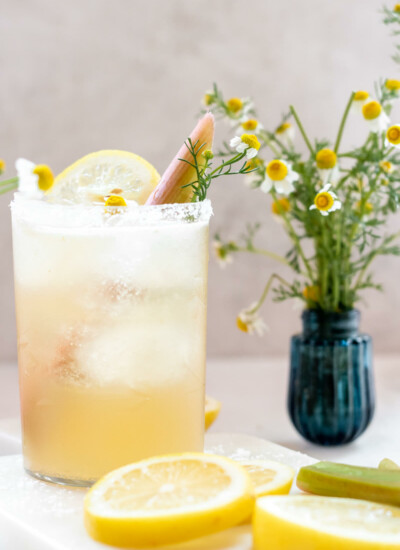 clear glass filled with rhubarb chamomile margarita with fresh lemon