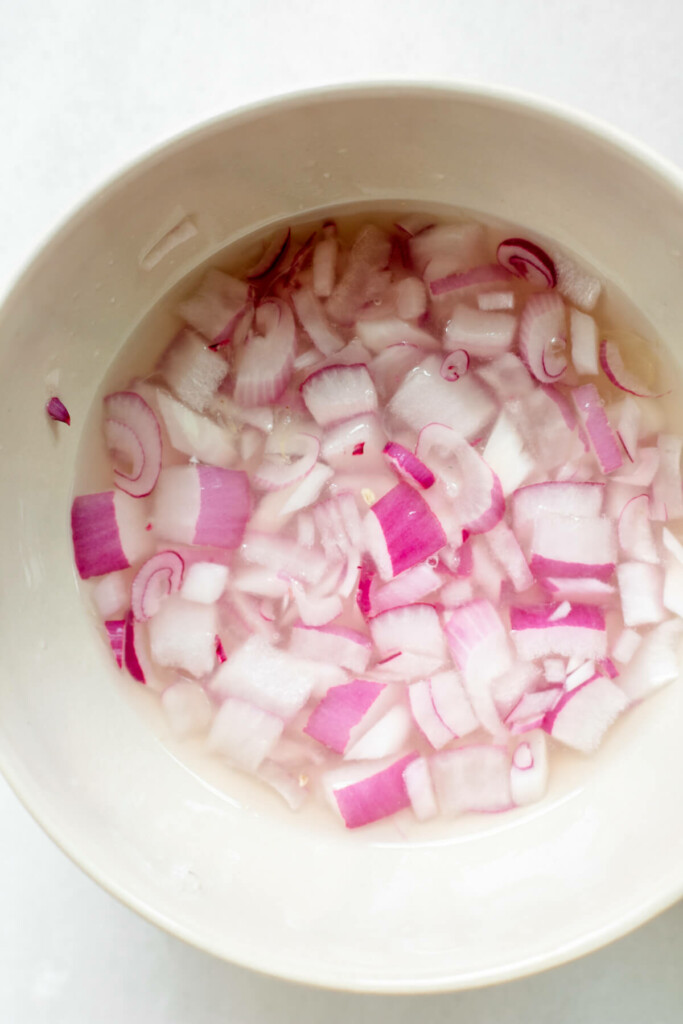 pickled red onions in a white bowl on a white background
