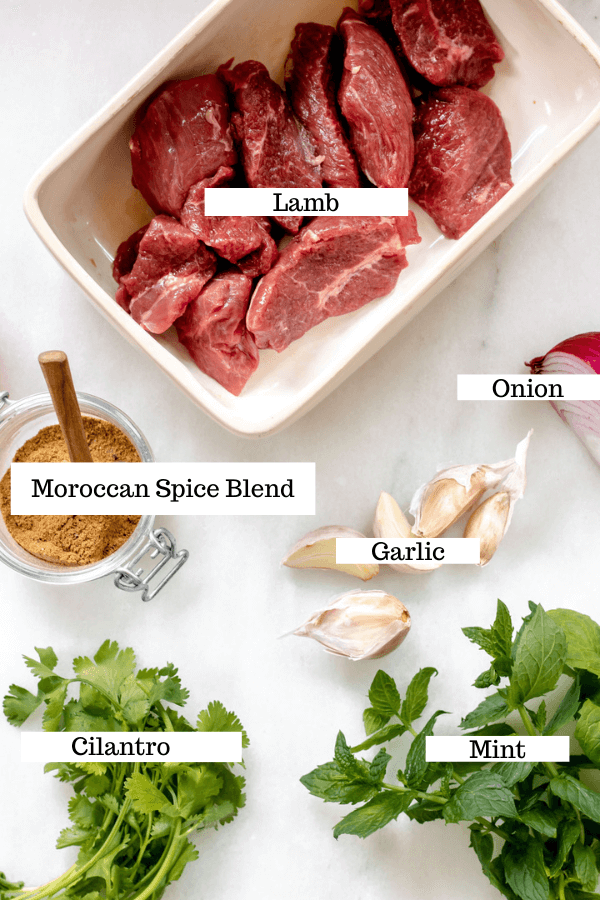 Table full of ingredients needed for lamb kebabs