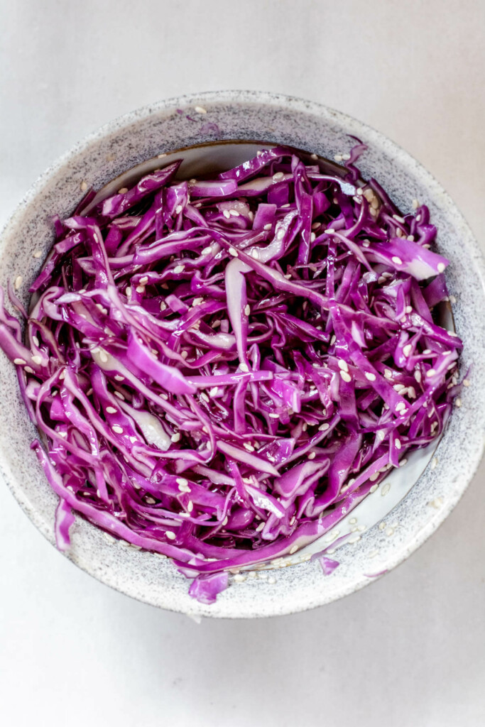 white bowl filled with purple cabbage and sesame seeds
