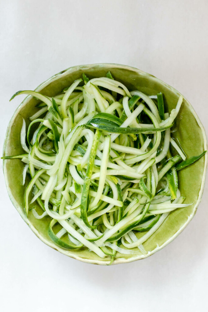 small green bowl filled with cucumber ribbons