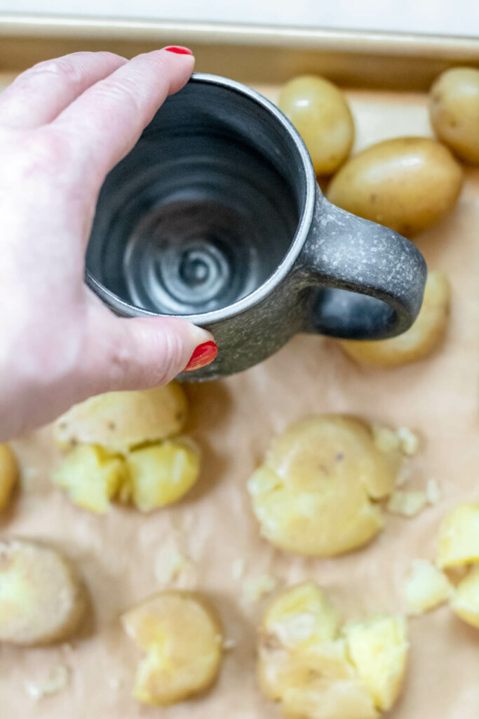 hand holding mug, smashing potatoes