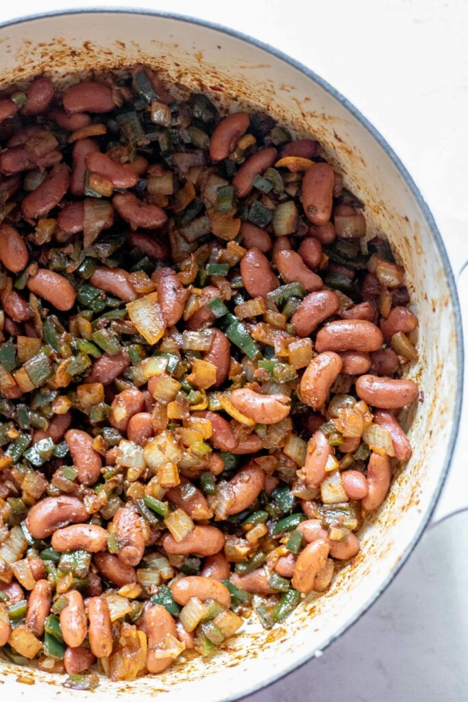 adding beans to poblano chorizo chili