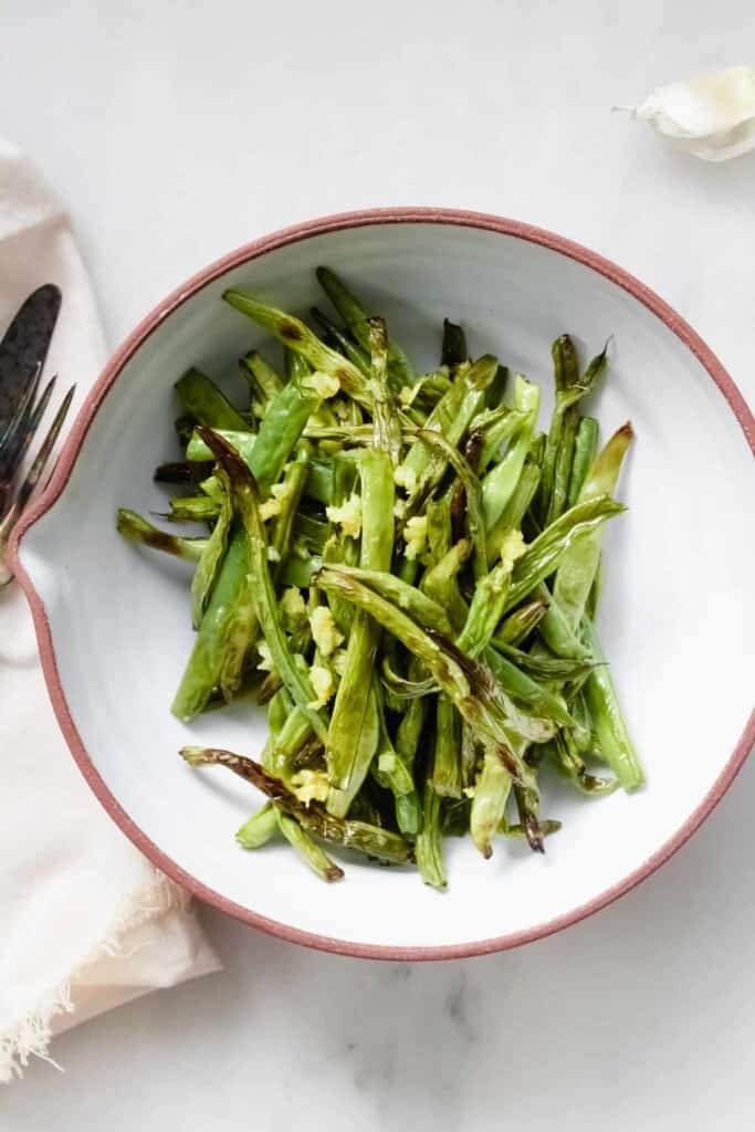 white stoneware bowl filled with crispy air fryer green beans