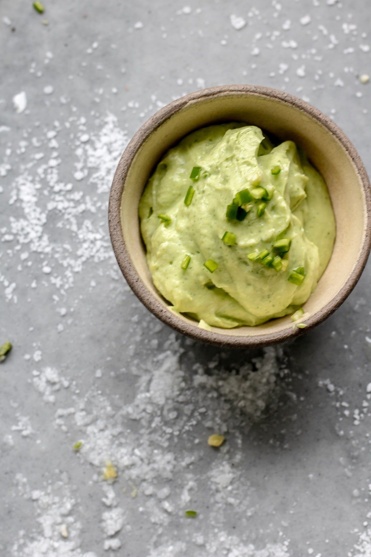 a small bowl of avocado crema on a grey platter