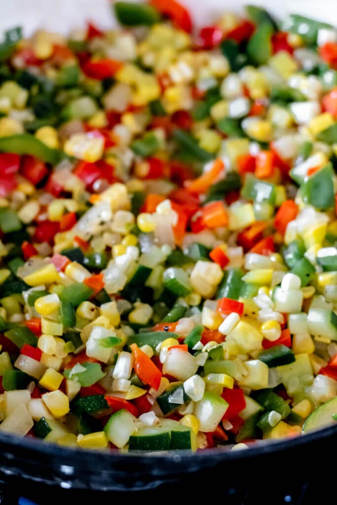 Close up shot of finely diced zucchini, onion, peppers, and corn for calabacitas