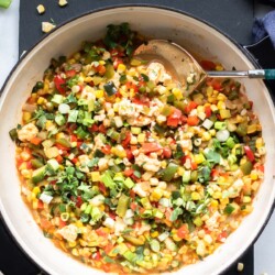 large pan of finely diced veggies with queso fresco on top, calabacitas