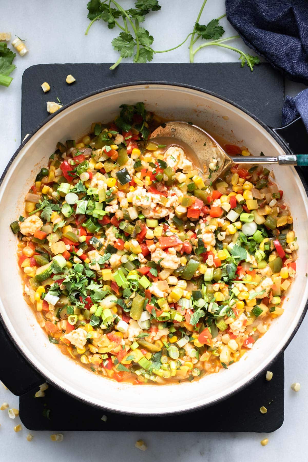 large pan of finely diced veggies with queso fresco on top, calabacitas