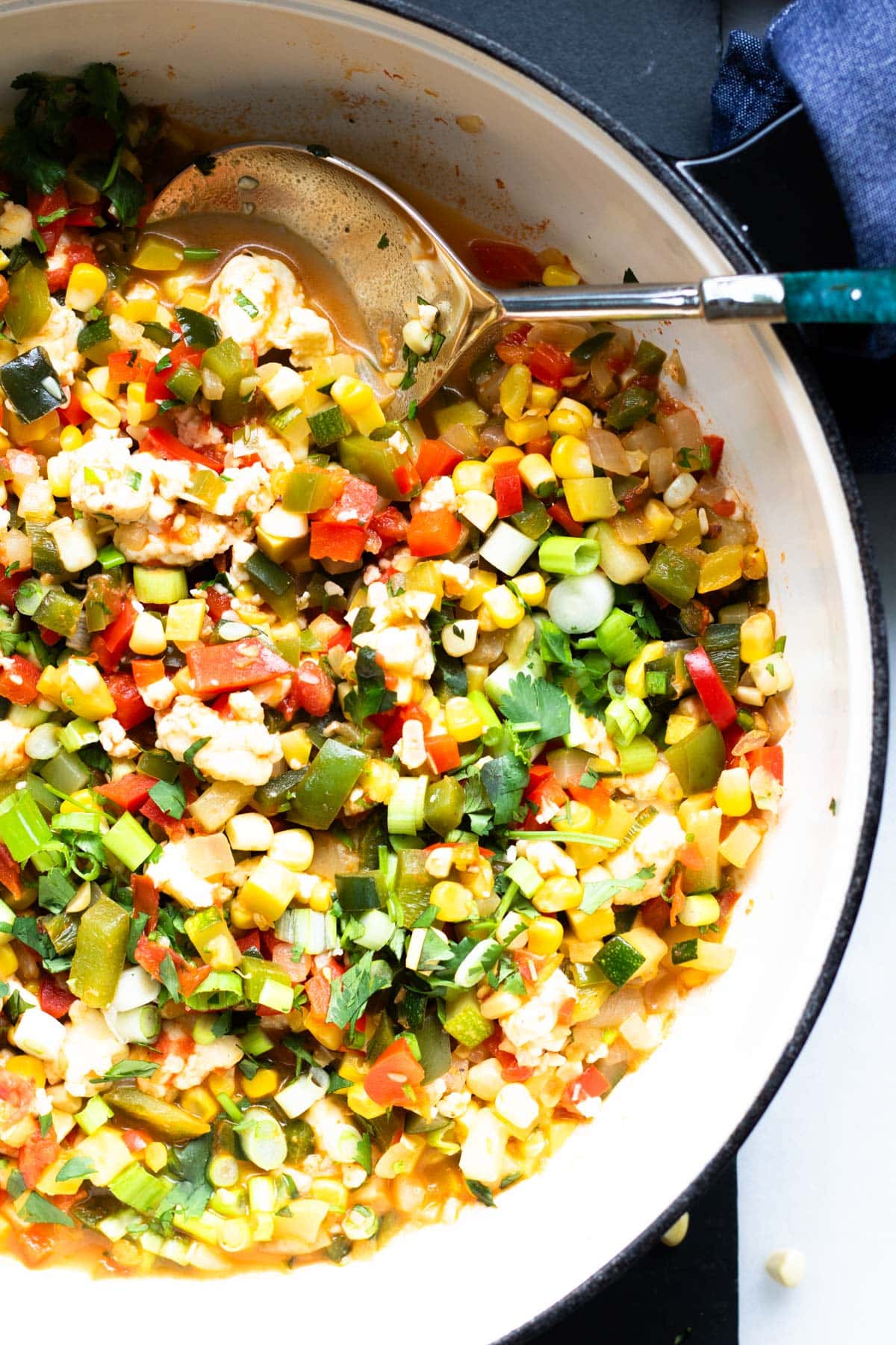 large pan of finely diced veggies with queso fresco on top, calabacitas