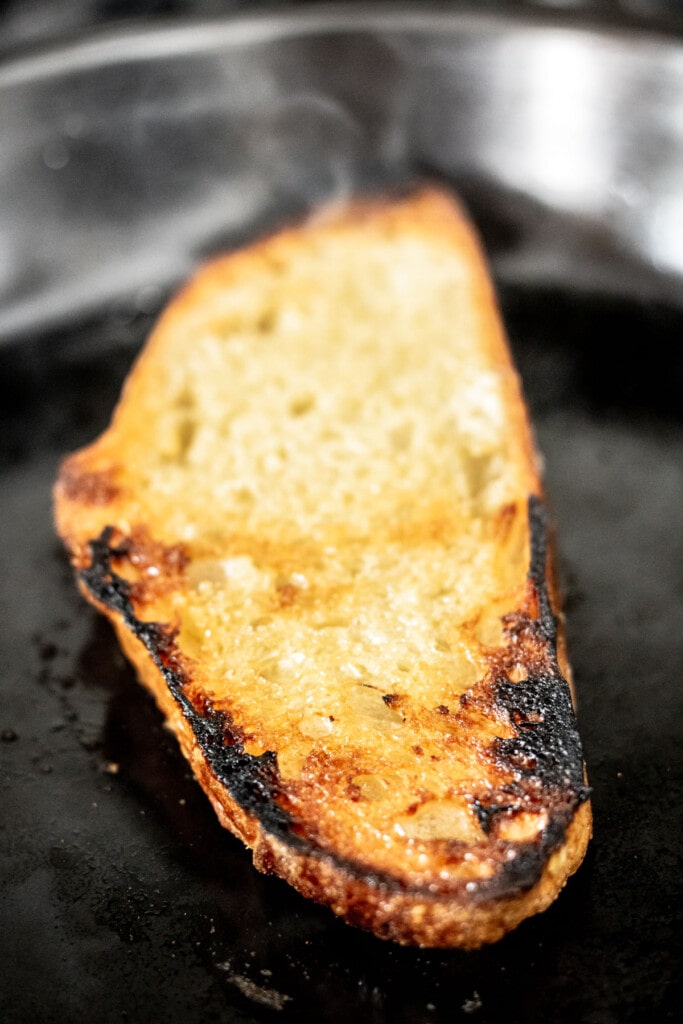 A slice of sourdough toast with blackened edges