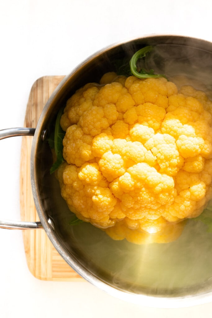 head of cauliflower in a pot of boiling water
