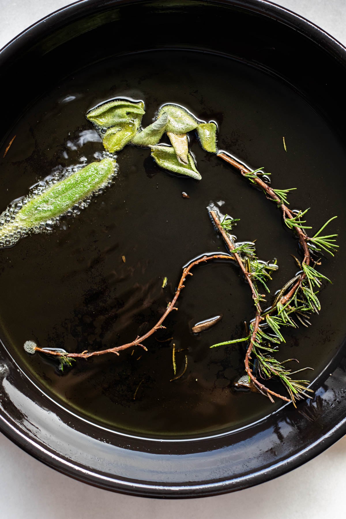 sage and rosemary fried in black pan