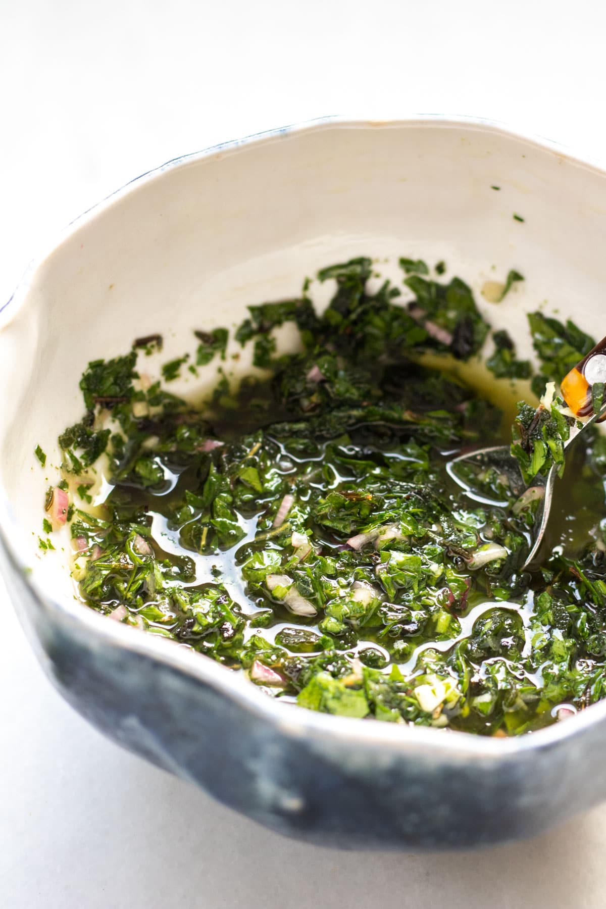 close up photo of salsa verde in a white bowl with a blue edge