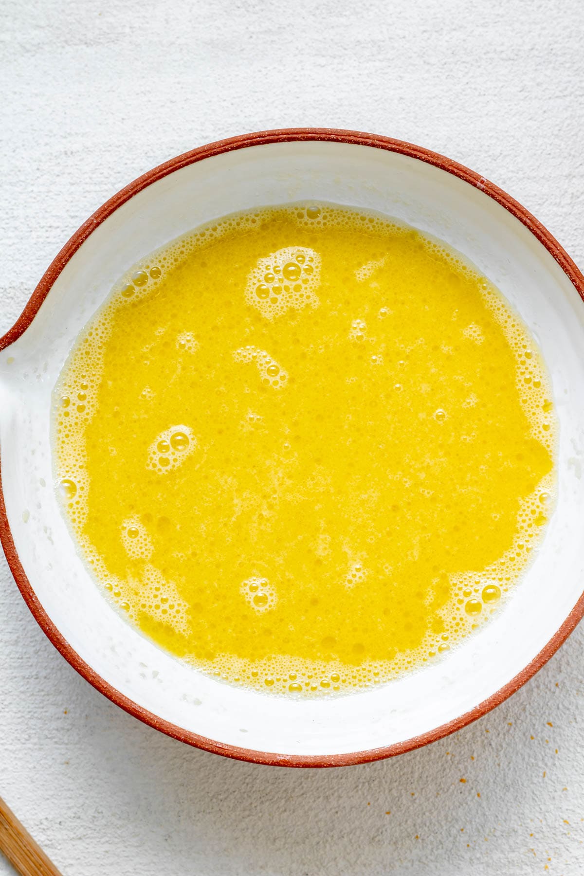 bowl full of wet ingredients for gluten free orange muffins