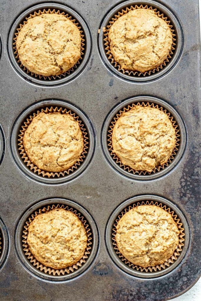 muffin tray filled with baked orange muffins