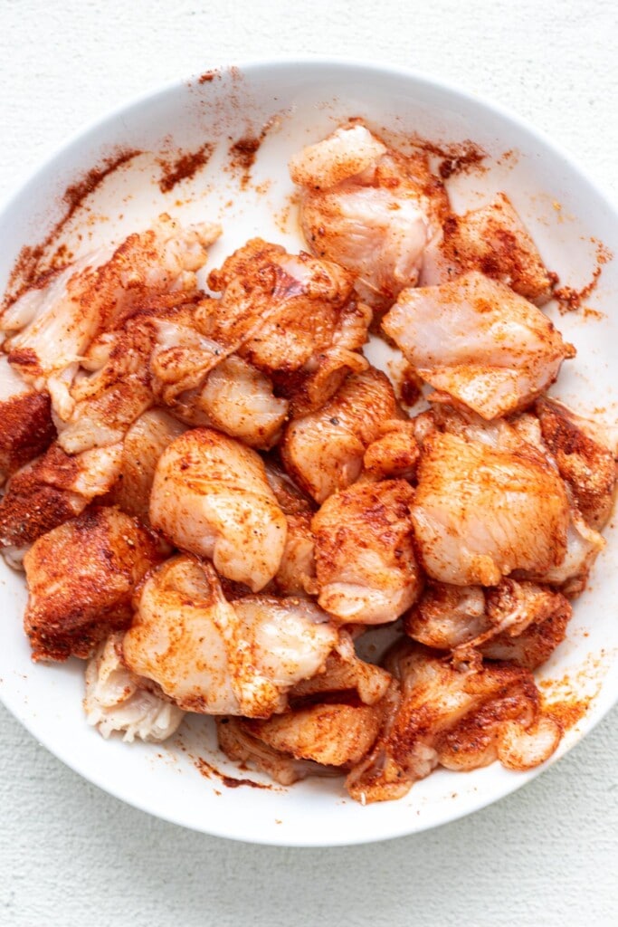 chicken tossed with paprika in a white bowl