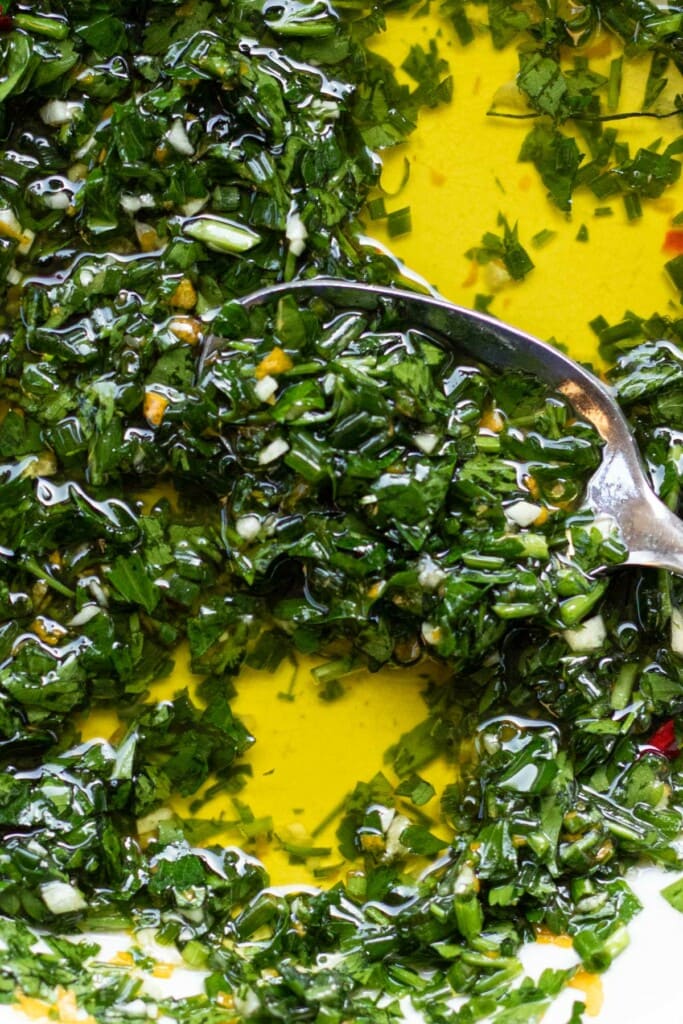 a close up shot of chive lemon gremolata with a spoon inside the bowl