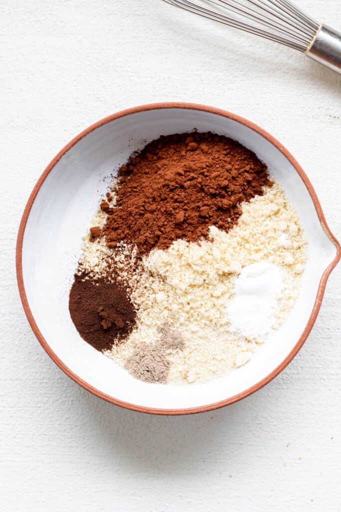 a bowl of gluten free biscotti dry ingredients, almond flour, coconut palm sugar, cocoa powder, espresso powder, cardamom and baking soda