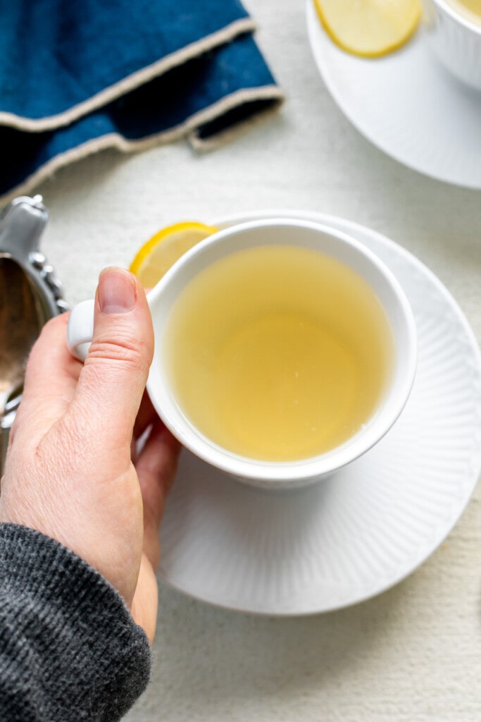 hand holding mug of lemon ginger tea