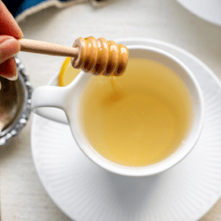 honey dripping into a mug of lemon ginger tea
