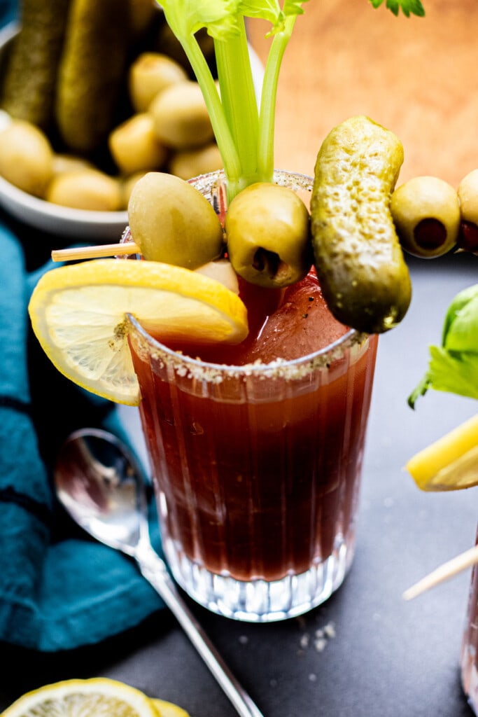 one glass of bloody mary with pickle, olive, celery, and lemon