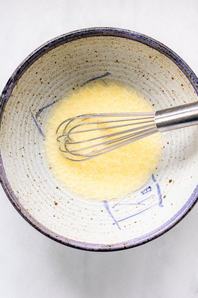 whisking egg and milk and oil in a bowl