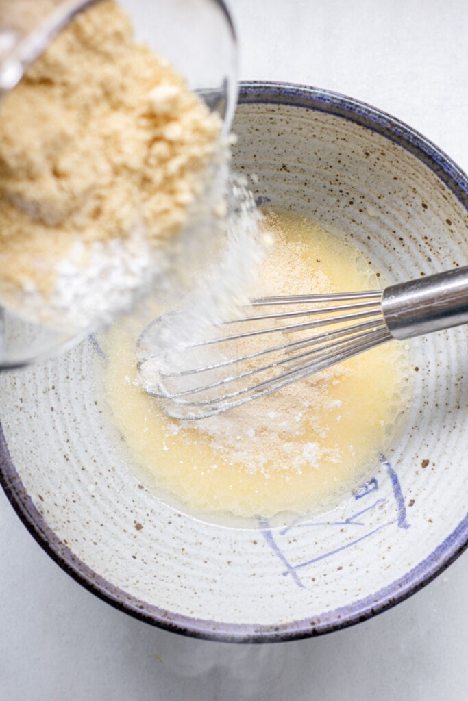 adding dry ingredients to wet ingredients in a bowl for gluten free irish soda bread