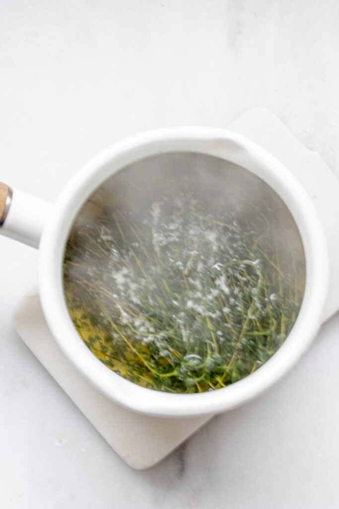 boiling thyme in a pot with steam rising
