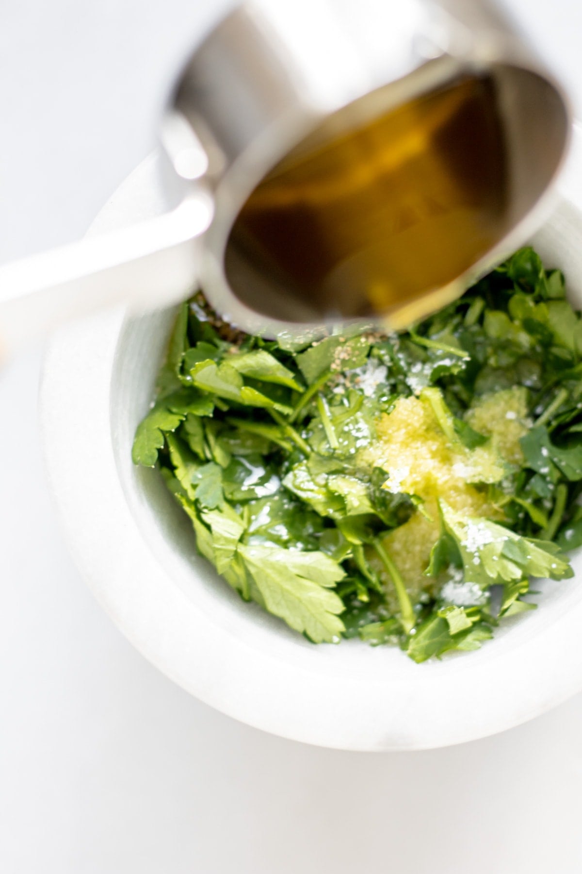 herbs and seasoning being mixed together with olive oil
