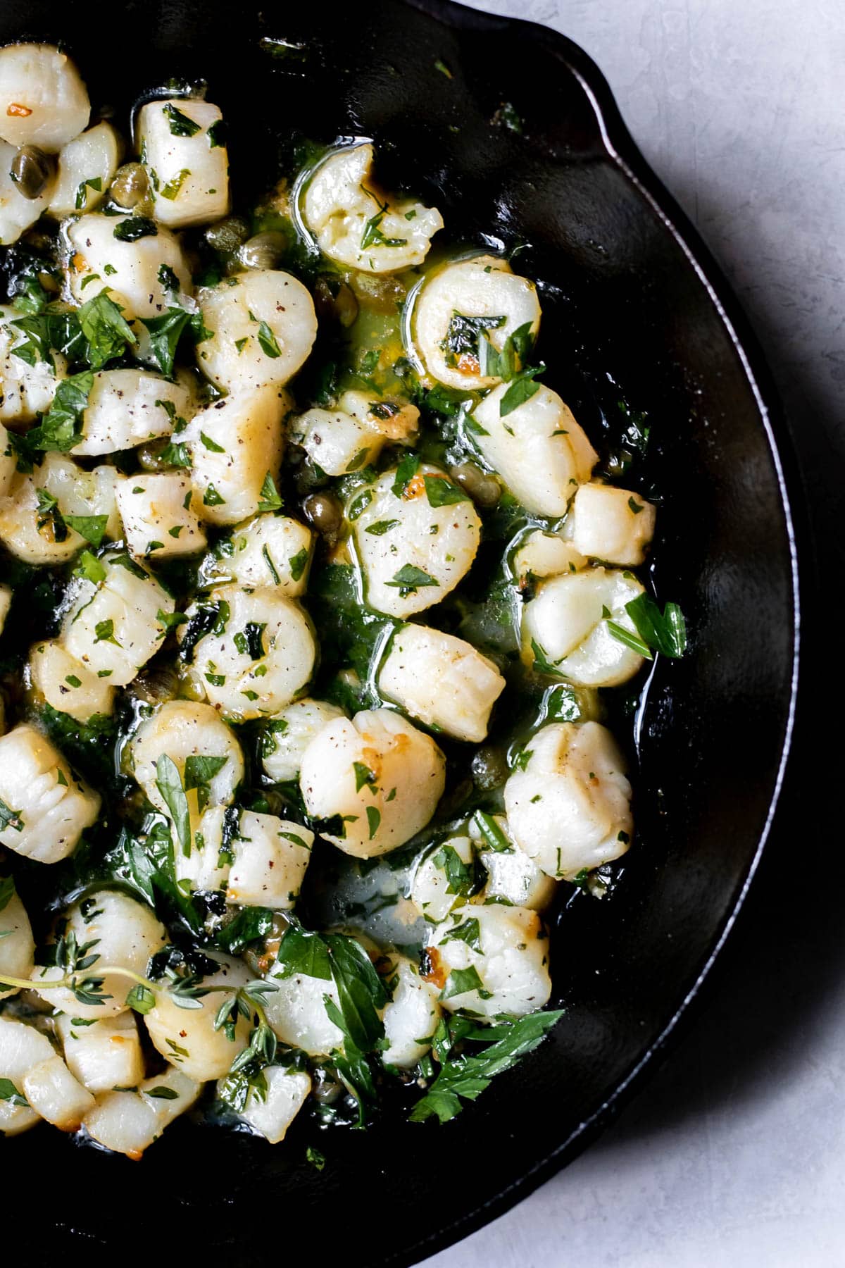 scallops and herbs cooked in a pan