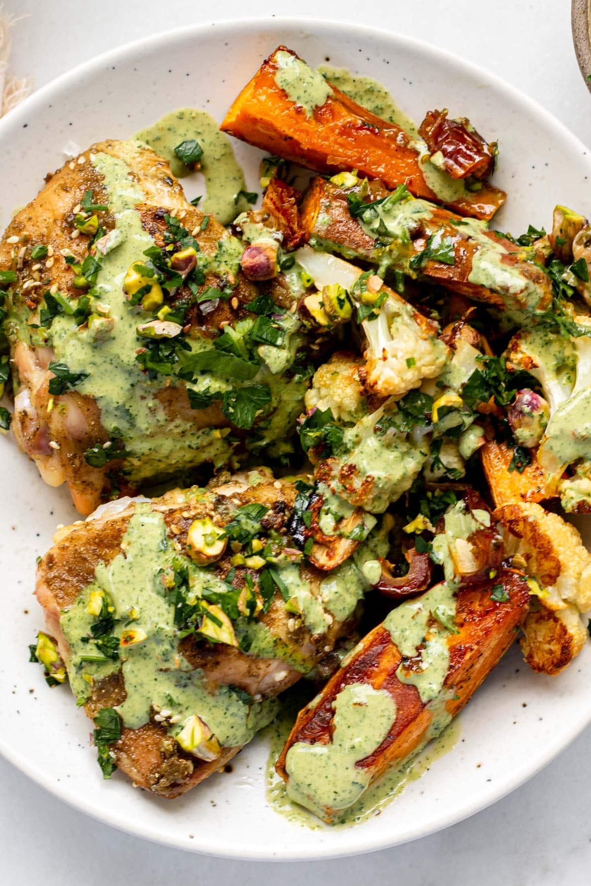 a close up shot of za'atar chicken with green tahini sauce