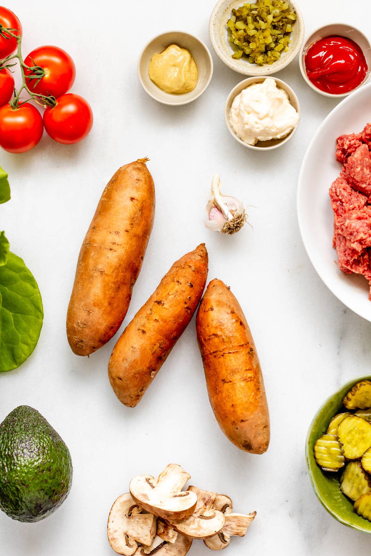Ingredients for a healthy burger bowl with sweet potatoes, ground beef, and mushrooms