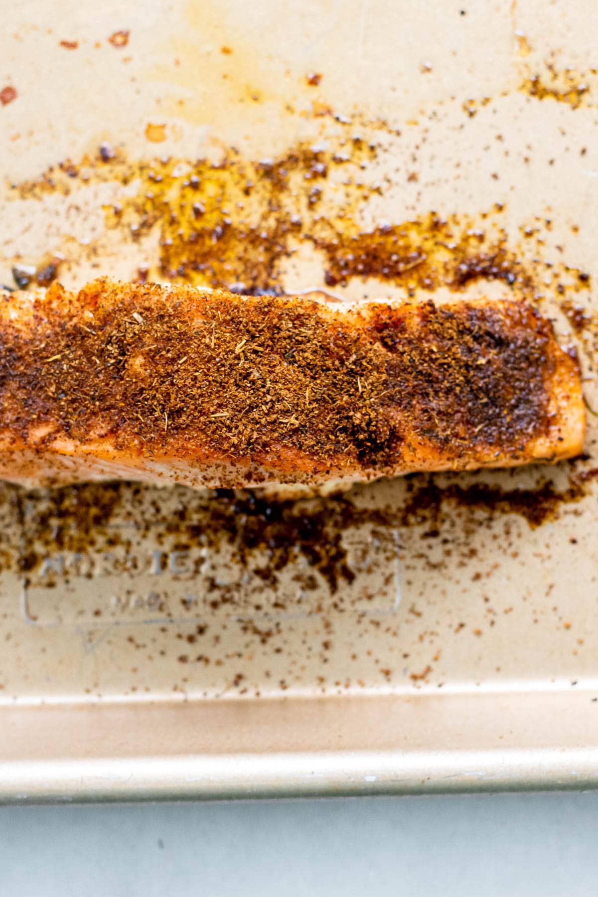 a perfectly cooked salmon filet on a cutting board with spices