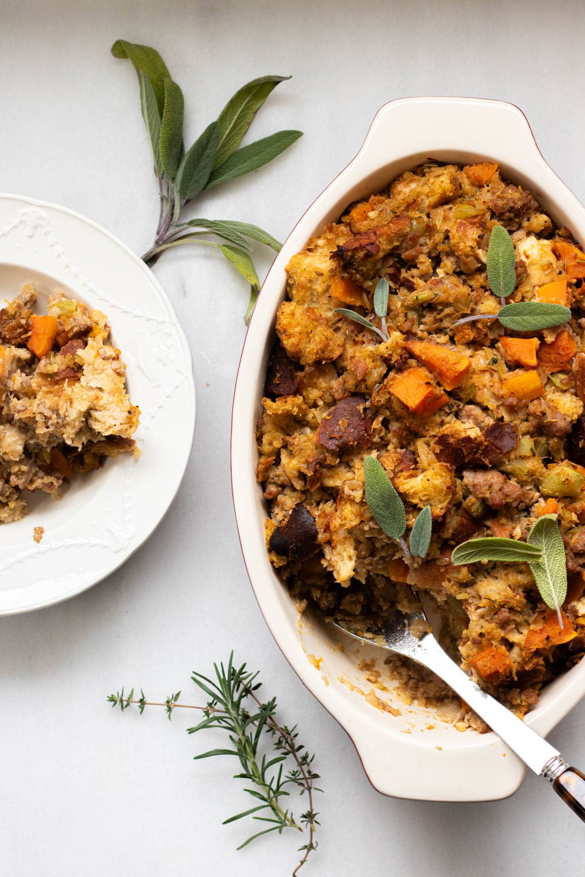 plate of butternut squash stuffing with a casserole full of stuffing to the side
