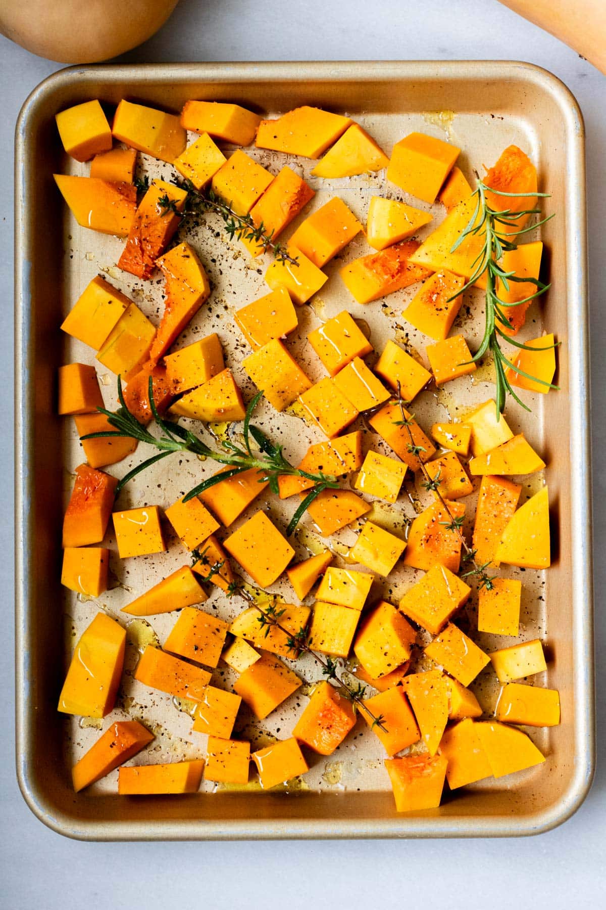 butternut squash roasted with herbs on a sheet tray
