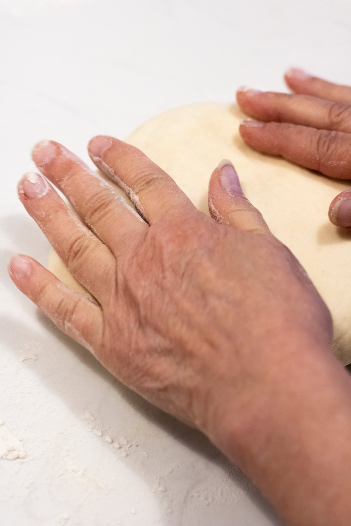 Hands making Hungarian kiffle dough into a ball prior to proofing