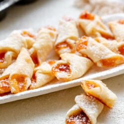 A plate of Hungarian Kiffles with tea in the background