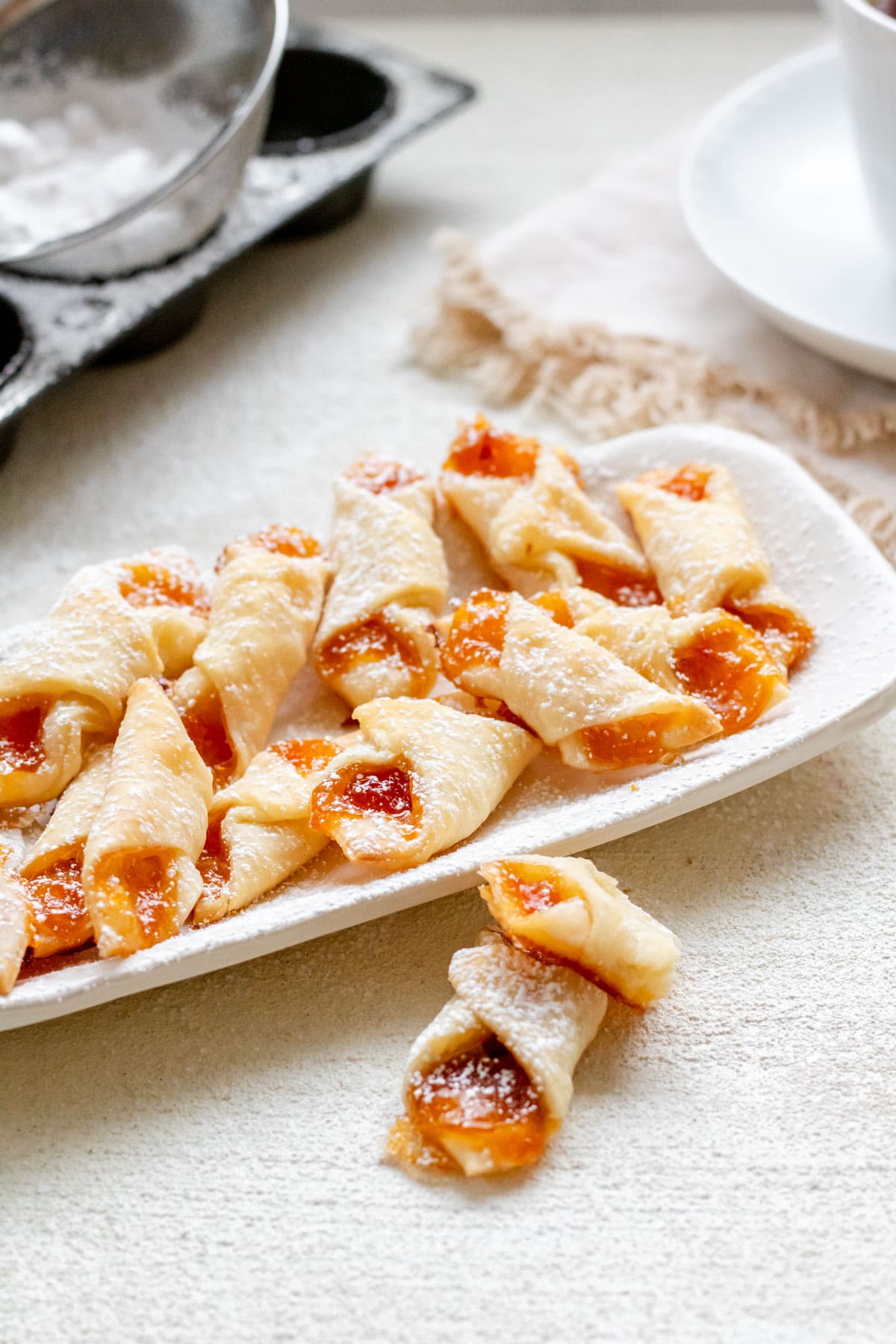 A plate of Hungarian Kiffles with tea in the background