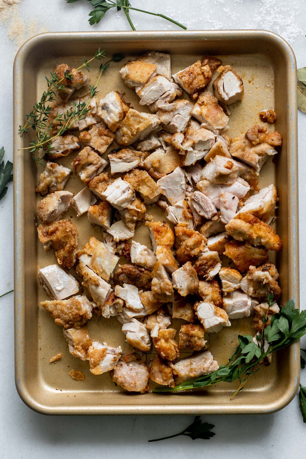 large sheet tray of seared chicken thigh